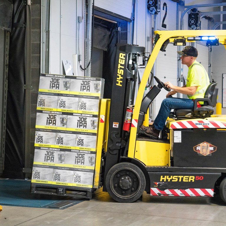 Man Riding A Yellow Forklift With Boxes 1267324